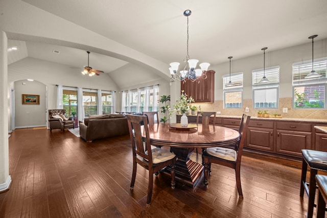 dining area with lofted ceiling, ceiling fan with notable chandelier, and dark hardwood / wood-style flooring