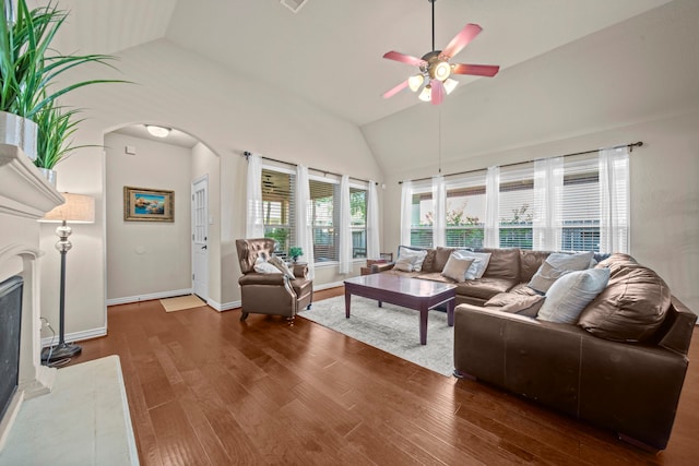 living room with a premium fireplace, ceiling fan, lofted ceiling, and dark hardwood / wood-style flooring