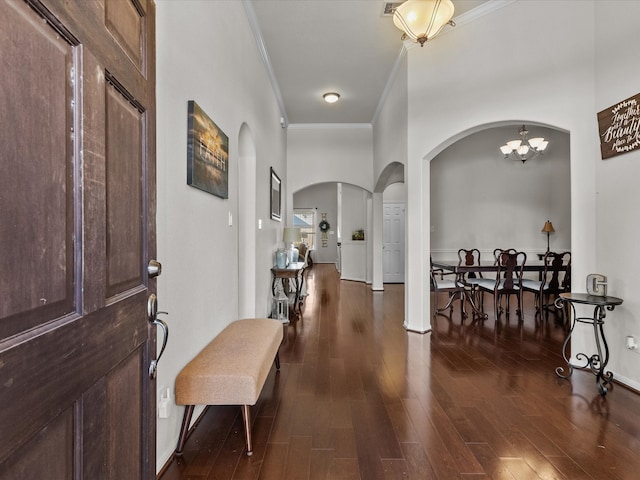 foyer entrance featuring dark hardwood / wood-style flooring, a high ceiling, a notable chandelier, and ornamental molding