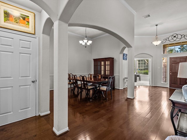 entrance foyer with dark hardwood / wood-style floors, crown molding, and a chandelier