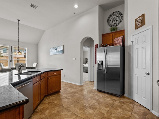 kitchen with sink, stainless steel appliances, vaulted ceiling, decorative light fixtures, and light tile patterned floors