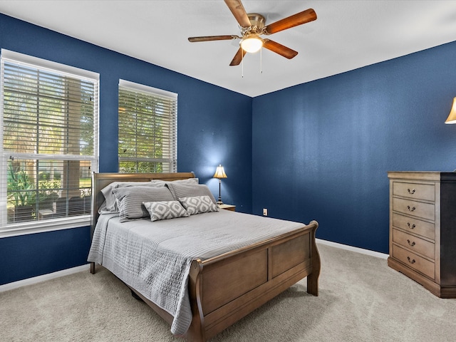 bedroom with ceiling fan, carpet floors, and multiple windows