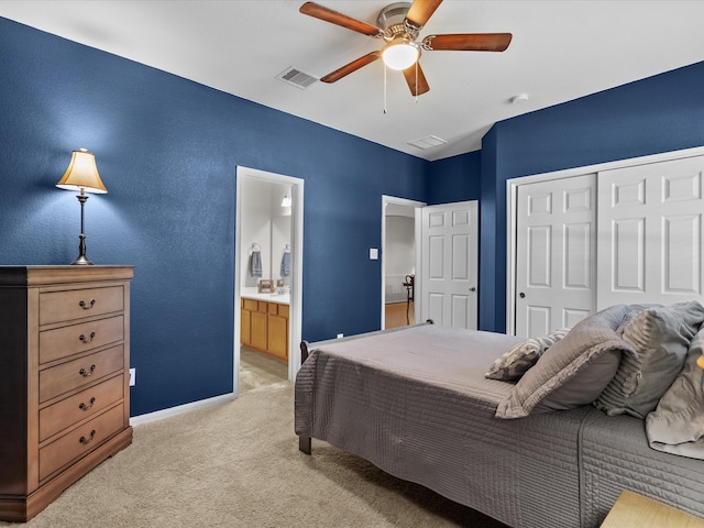 carpeted bedroom featuring ceiling fan, ensuite bathroom, and a closet