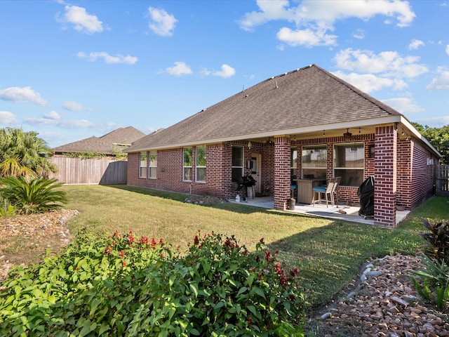 rear view of house featuring a yard and a patio