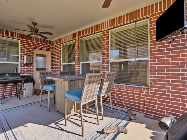 view of patio / terrace featuring a grill, ceiling fan, and a bar