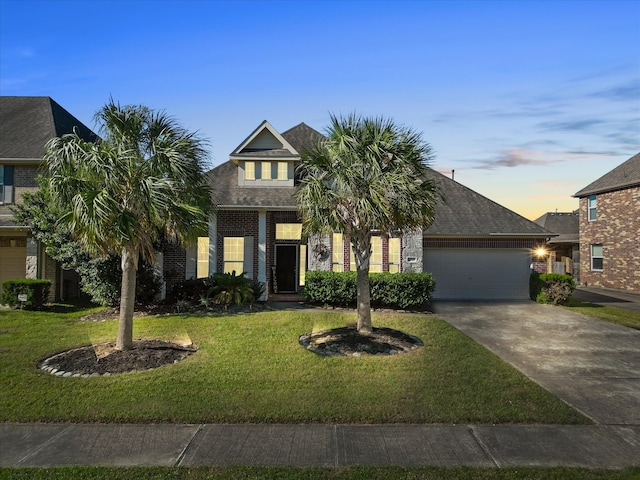 view of front of home with a garage and a lawn