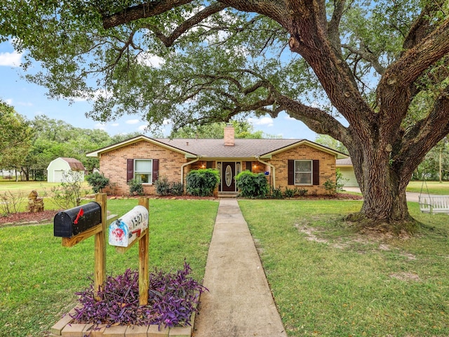 ranch-style home featuring a front yard and a shed