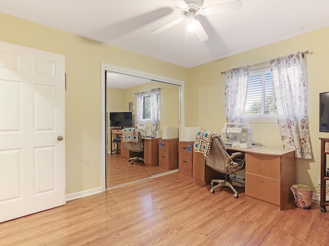 office with light hardwood / wood-style floors, a healthy amount of sunlight, and ceiling fan