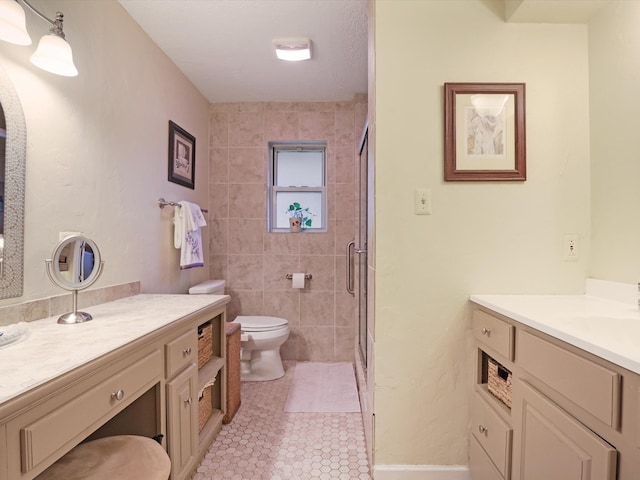 bathroom with vanity, a shower with shower door, toilet, and tile patterned flooring