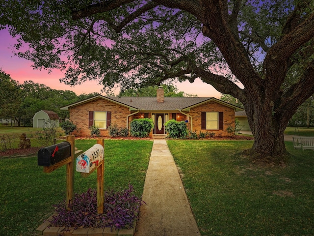 single story home with an outbuilding and a lawn