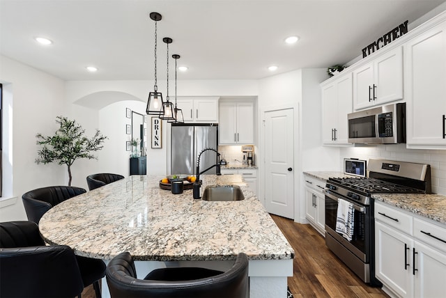 kitchen featuring appliances with stainless steel finishes and an island with sink