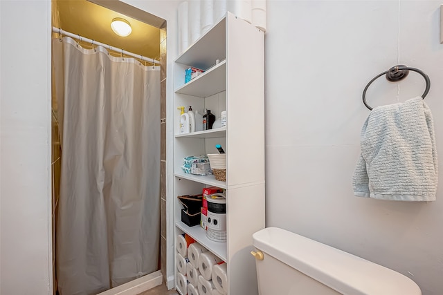 bathroom with curtained shower and toilet