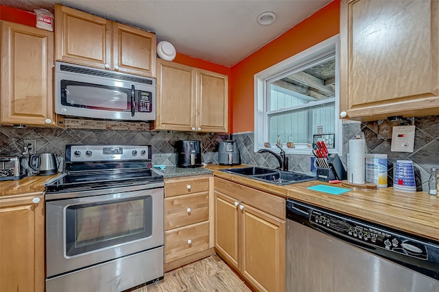 kitchen with backsplash, light brown cabinetry, sink, and appliances with stainless steel finishes