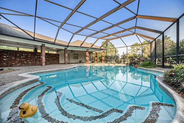 view of pool with ceiling fan, a patio area, and glass enclosure