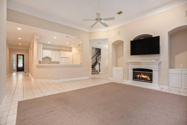 unfurnished living room featuring french doors, light tile patterned flooring, ceiling fan, and crown molding