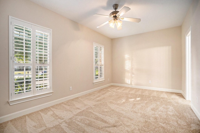 empty room featuring light colored carpet and ceiling fan