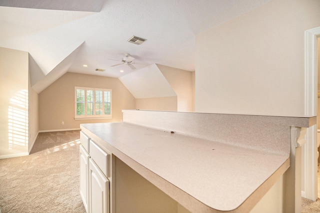 interior space with lofted ceiling, a textured ceiling, ceiling fan, and light colored carpet