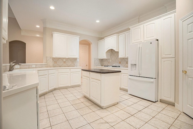 kitchen featuring white appliances, white cabinetry, backsplash, and sink