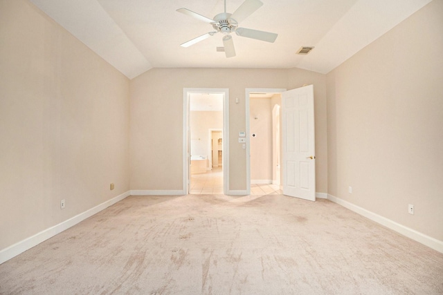 unfurnished bedroom with ceiling fan, vaulted ceiling, and light carpet