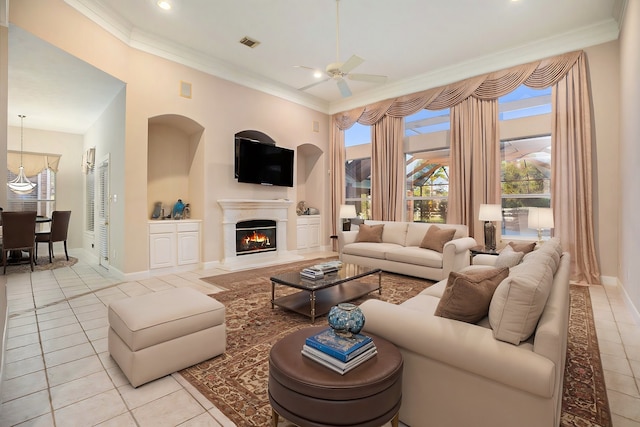 tiled living room with ceiling fan and crown molding