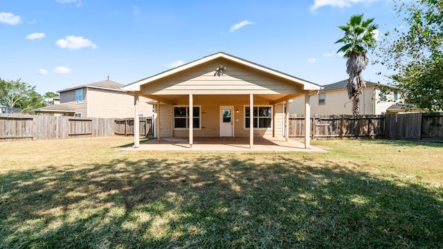 back of property with a yard and a patio area