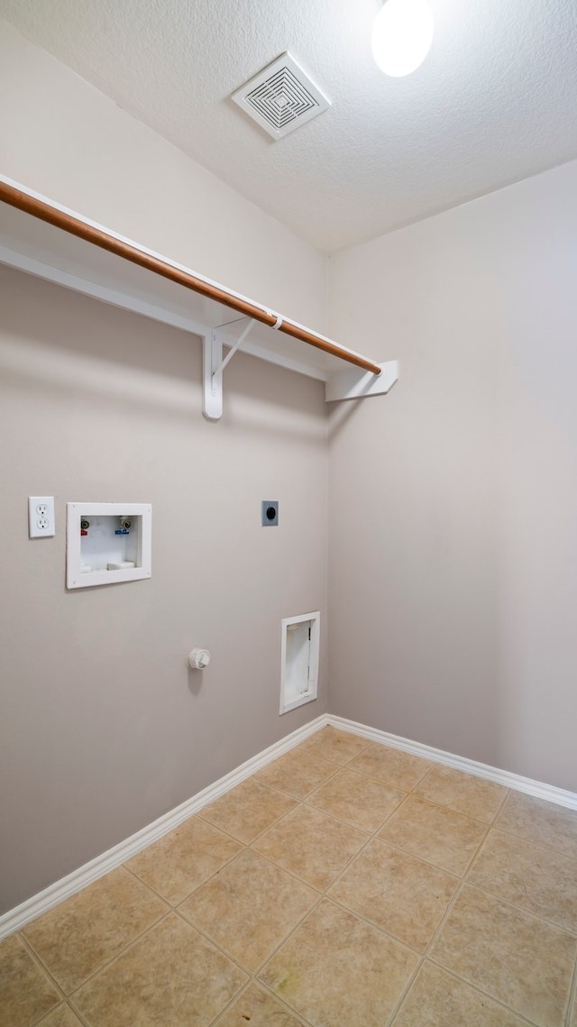 clothes washing area featuring hookup for an electric dryer, light tile patterned flooring, hookup for a washing machine, and a textured ceiling