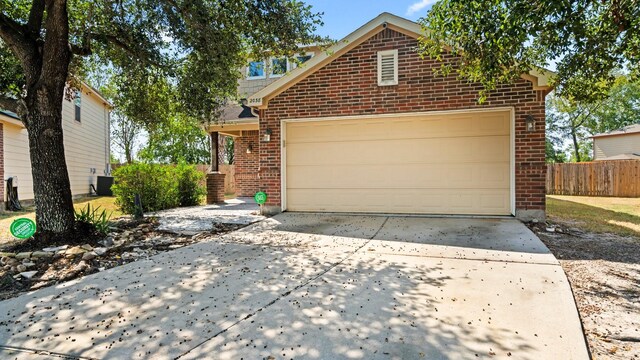 2038 Adobe Stone Dr, Humble, TX 77396 - view of front of property with central air condition unit, fence, brick siding, driveway, and a garage