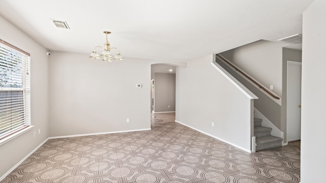 unfurnished room featuring an inviting chandelier