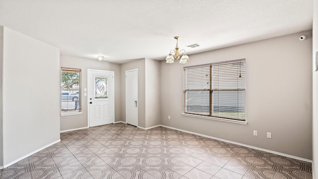 2038 Adobe Stone Dr, Humble, TX 77396 - foyer entrance featuring an inviting chandelier, visible vents, and baseboards