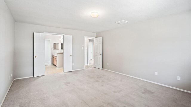 2038 Adobe Stone Dr, Humble, TX 77396 - unfurnished bedroom featuring ensuite bath, light carpet, and baseboards
