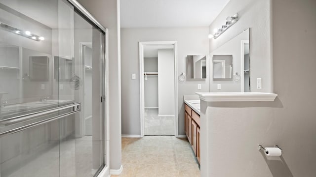 2038 Adobe Stone Dr, Humble, TX 77396 - full bath featuring a stall shower, baseboards, tile patterned flooring, vanity, and a spacious closet
