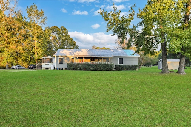 view of front facade with a storage shed and a front yard