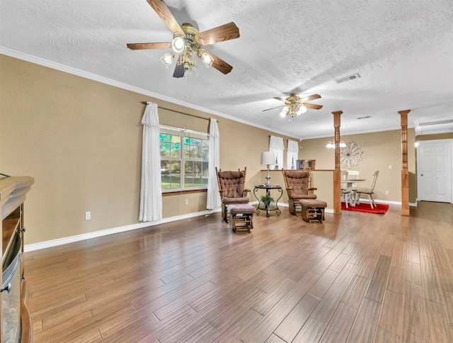 sitting room featuring crown molding, hardwood / wood-style flooring, a textured ceiling, and ceiling fan with notable chandelier