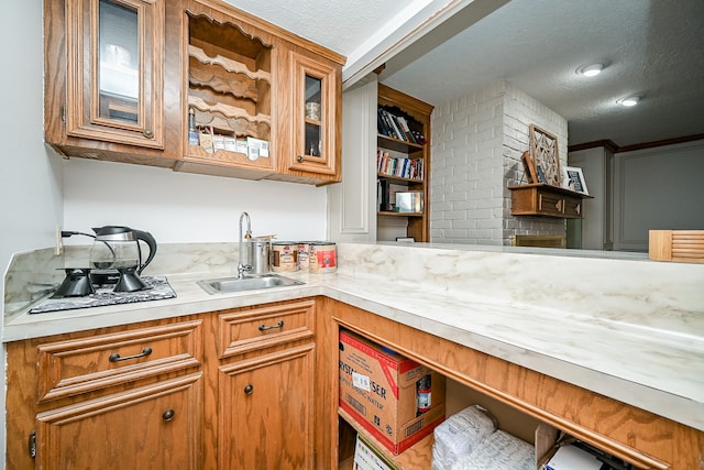 kitchen with backsplash, a textured ceiling, and sink