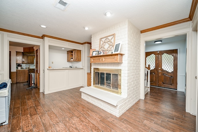 living room featuring dark wood-type flooring, a textured ceiling, and a fireplace