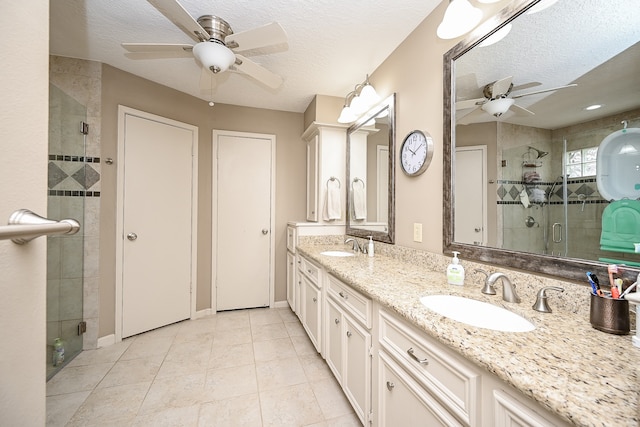 bathroom featuring vanity, a textured ceiling, and a shower with shower door