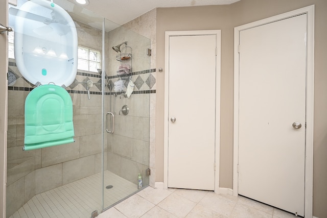 bathroom with a shower with door and tile patterned flooring