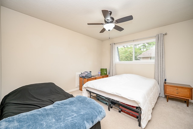 carpeted bedroom with a textured ceiling and ceiling fan