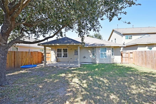 back of house with a yard and a patio