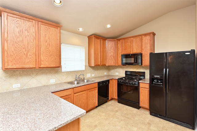 kitchen with lofted ceiling, sink, black appliances, light stone countertops, and tasteful backsplash