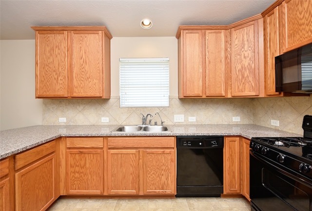 kitchen with sink, black appliances, decorative backsplash, and light stone counters