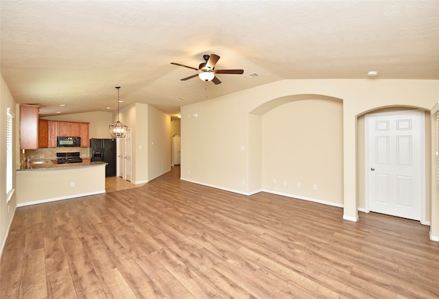 unfurnished living room featuring light hardwood / wood-style floors, a textured ceiling, sink, and ceiling fan with notable chandelier