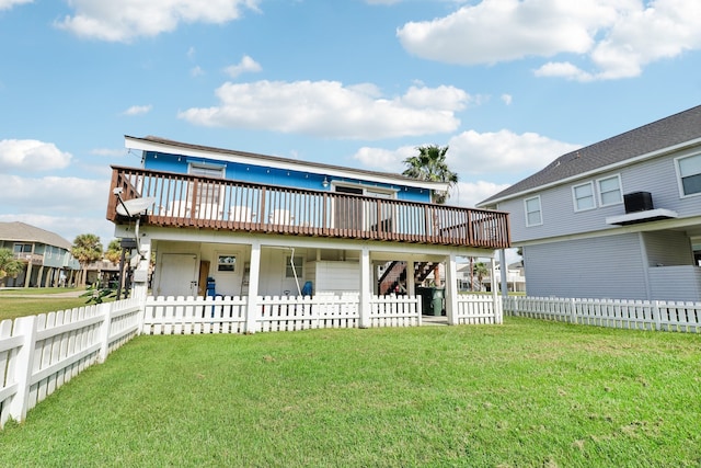 back of property featuring a wooden deck and a lawn