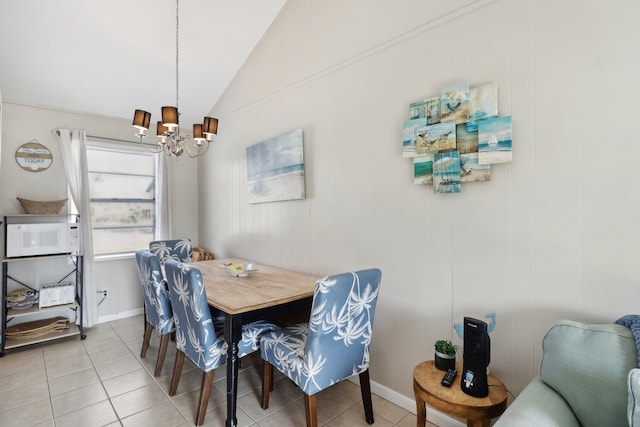 dining space with an inviting chandelier, tile patterned flooring, and vaulted ceiling