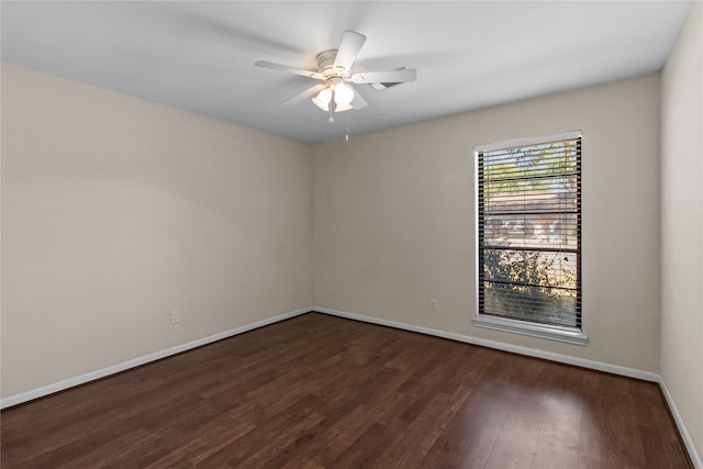 empty room with ceiling fan and dark hardwood / wood-style flooring