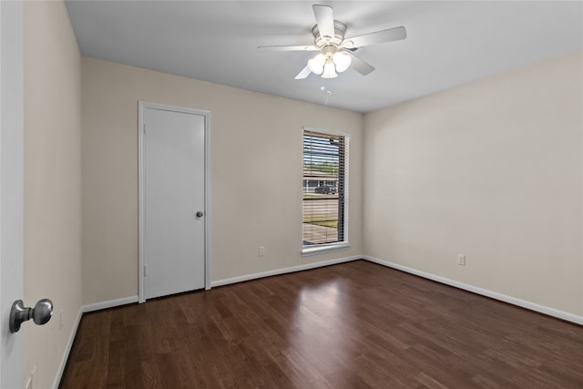 empty room with ceiling fan and dark hardwood / wood-style floors