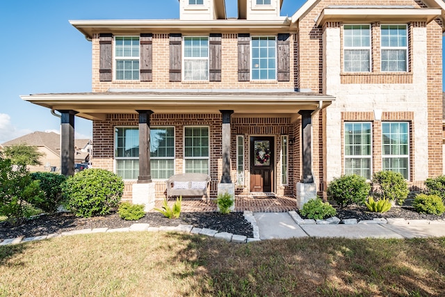 view of front of house with a front yard and a porch