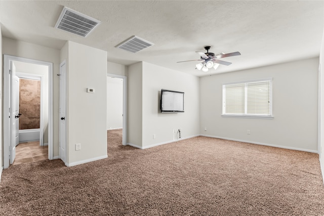 interior space with ceiling fan, carpet flooring, and a textured ceiling