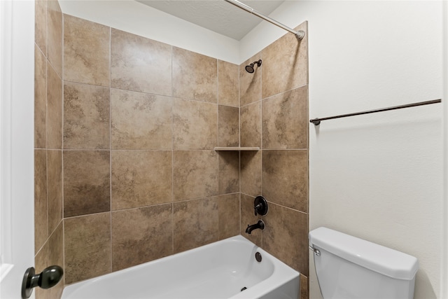 bathroom with tiled shower / bath combo and toilet