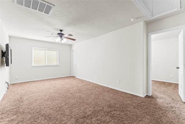 carpeted spare room featuring ceiling fan and a textured ceiling